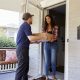 Courier Delivering Package To Woman At Home